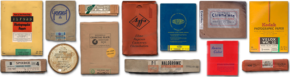 A row of colorful packages of paper from different companies and time periods.