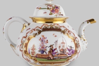 A teapot with decorative pink and gold designs.