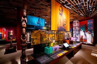 A colorful exhibition space with African objects and photographs