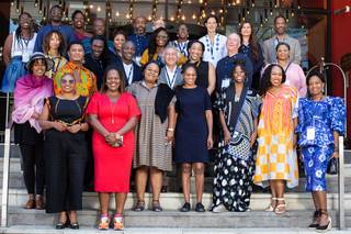 The 2024-25 cohort of Yale Directors Fellows stand in a group and smile at the camera.