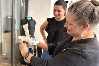 Two woman set up a handheld XRF. 