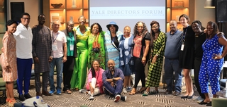 A group photo with individuals standing in a row smiling at the camera.