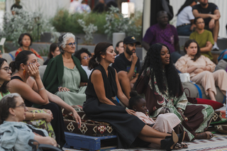 An audience listens attentively while facing the same direction.