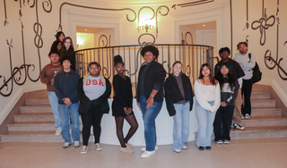 Students pose between two staircases.