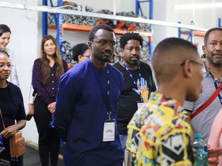Man in navy blue shirt and a name badge listens attentively.
