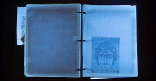 A binder open to a page with a man's composite under UV light.