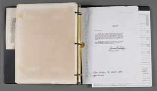 An open binder with discolored pages on the left side.